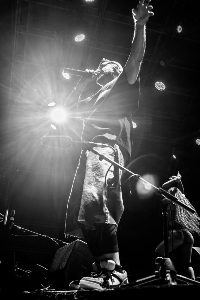 Sean Paul backlight and raised arm live performance in Milan, Italy, at Kozel Carroponte, 2026